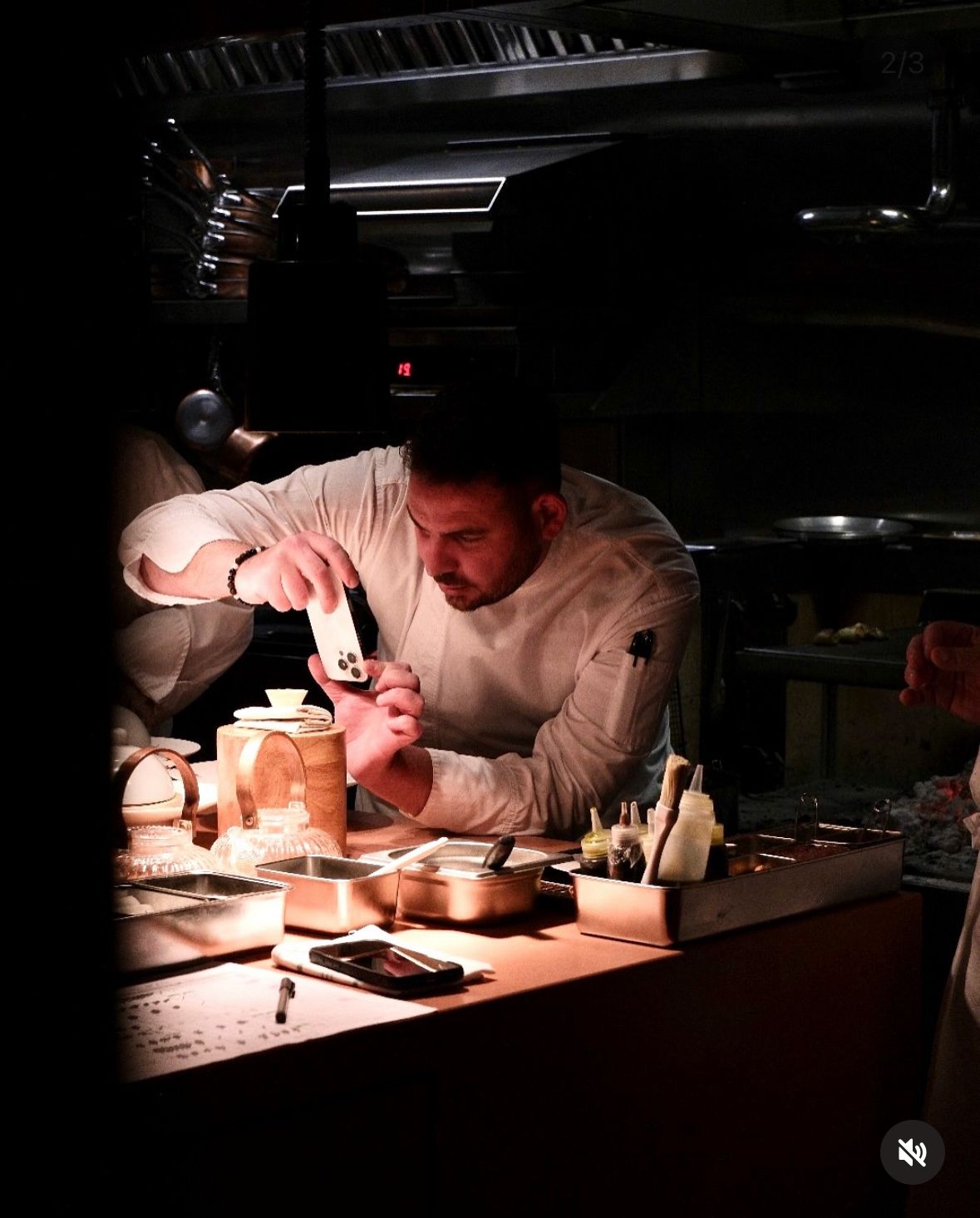 Chef plating by phone-light in the pass